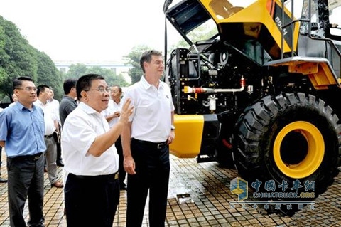 广西柳工曾光安董事长(中)向冯天祥总裁(右)介绍公司产品
