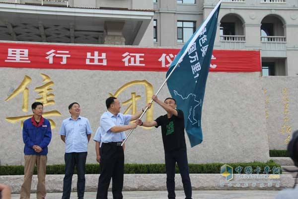 姜总把奥驰万里行活动的旗帜交付出征人员