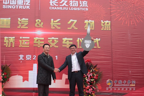中国重汽销售部北京分公司总经理牟磊向长久物流合作发展部部长李涛交付车钥匙