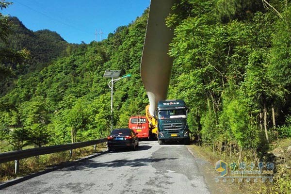 杰狮牵引车装载风车叶片在上山路上