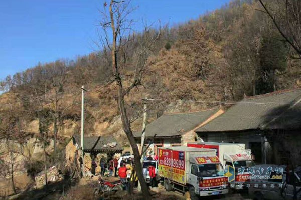 卢财国带着生活日用品与爱人，同事一同进山去看望老人