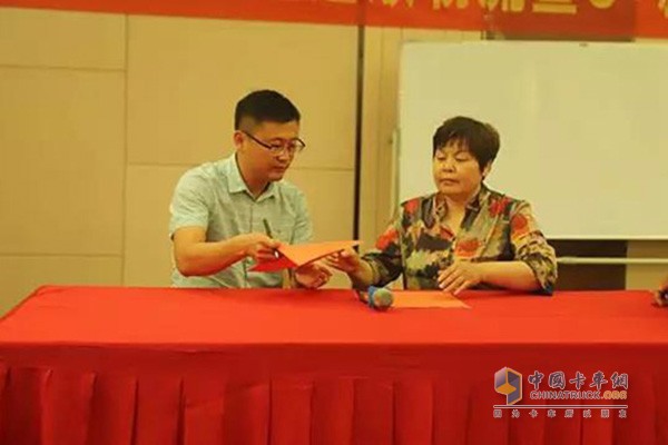 中集联合卡车营销公司山东大区经理刘国笋(左)与高青途顺物流公司总经理王红燕(右)签约订单