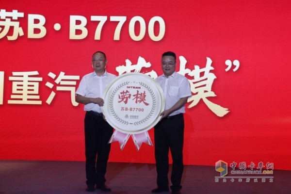 中国重汽副总裁刘培民(右)为车主付忠艳(左)颁发“劳模”荣誉奖章