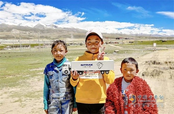 孩子们和中国重汽汕德卡合影