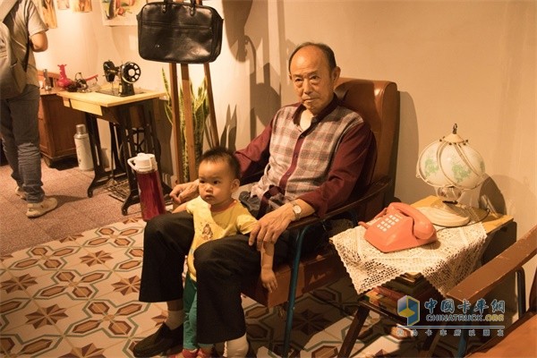上汽红岩爷爷带着孙子坐在椅子上