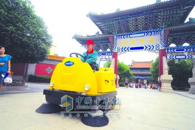 工人们正在操作新款电力清扫车对公园内的地面进行清洁