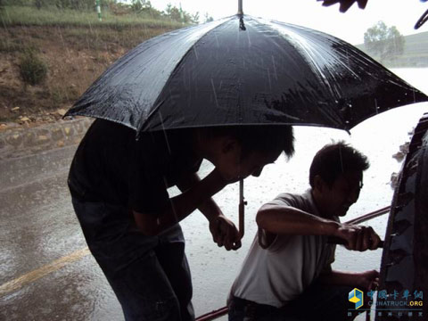 陕汽大飞达服务站的李泽平师傅冒雨为用户修车