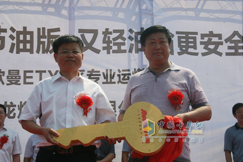 山东同鑫源汽车销售有限公司总经理付福元与山东翔龙煤炭洗选有限公司副总汪明勤(右)交付售后服务车辆钥匙