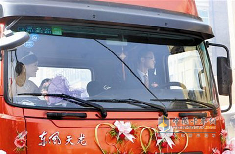 新郎新娘坐在东风天龙的婚车上